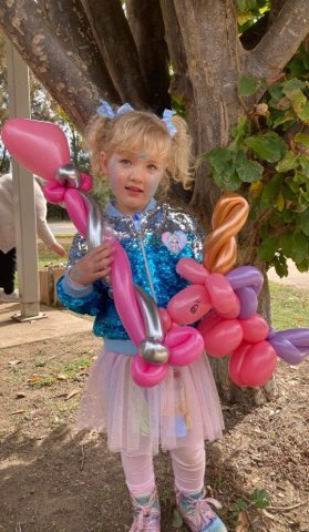 Child holding colourful balloon creations