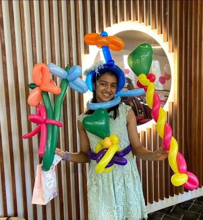 A child wearing balloon creations