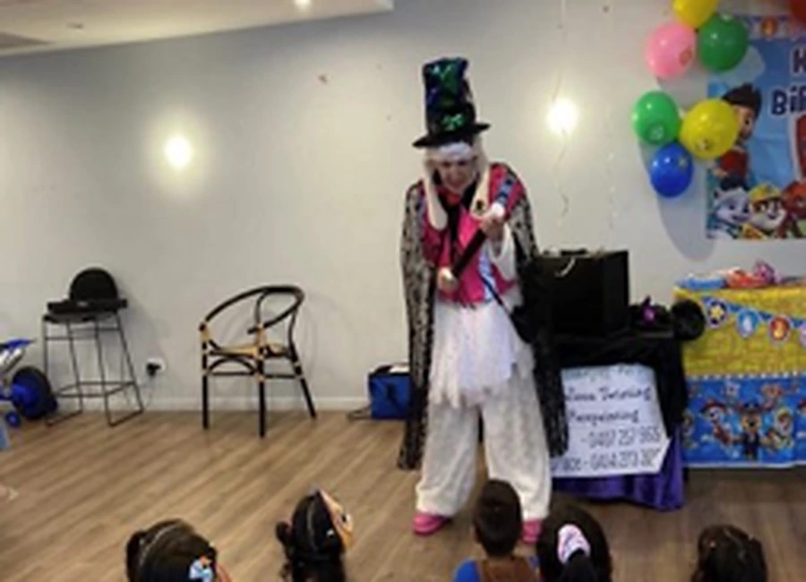 Dee performing magic for children